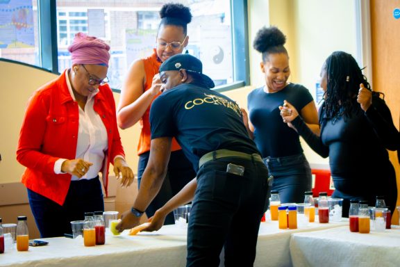 Group of people enjoying a social gathering with drinks and lively interaction.